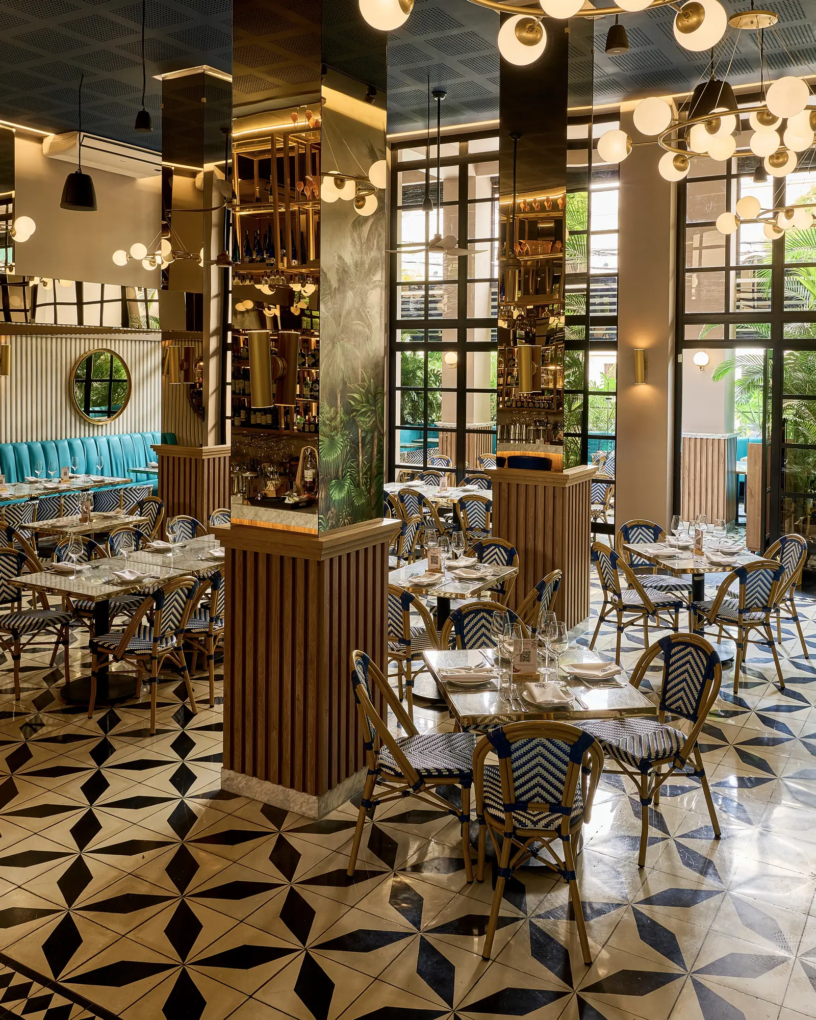 Salón de Odiseo: piso de estrellas, banca turquesa, sillas de ratán y candelabros de globos.